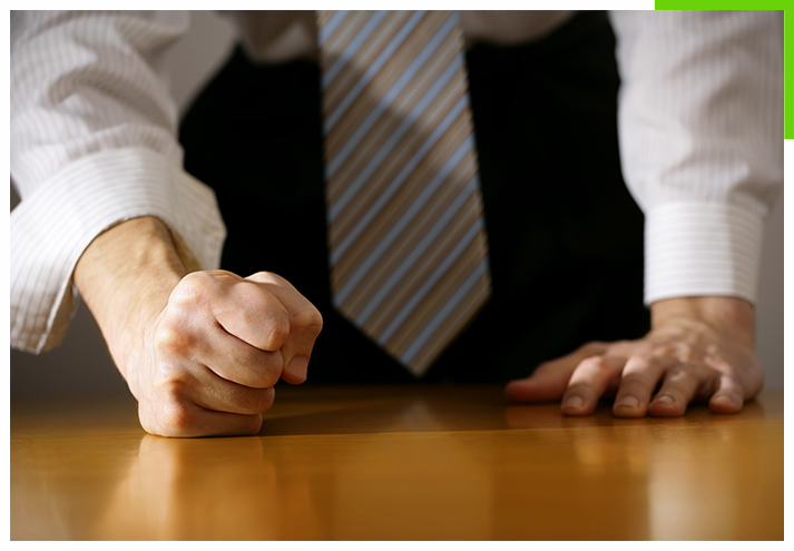 businessman hitting table with clenched fist